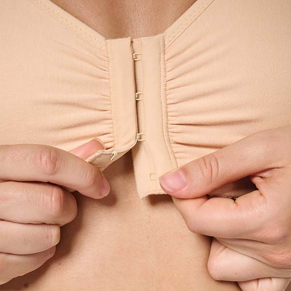 Close-up of the Amoena Frances Front Fastening soft wireless bra showing the hook-and-eye fastener being done up.