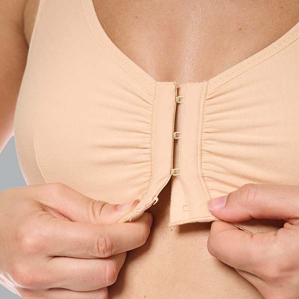 Close-up of the Amoena Fleur Front Fastening soft wireless bra showing the hook-and-eye fastener being done up.