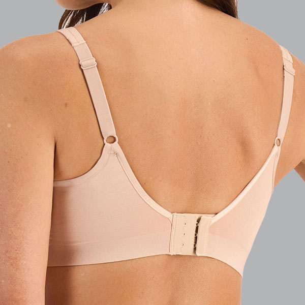 Back of the nude Berlei YWKX post-surgery bra showing the lower curved back, upward curved underarm band, and narrow straps.